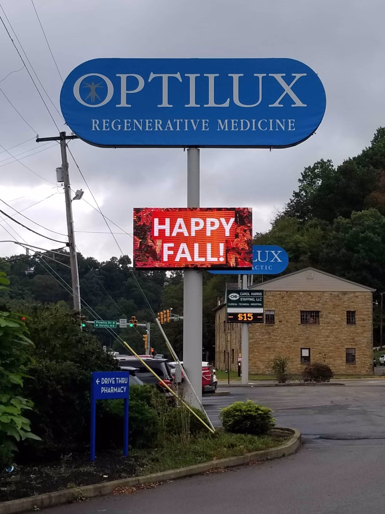 Optilux's digital sign in their parking lot that was created and installed by Talk'n Signs